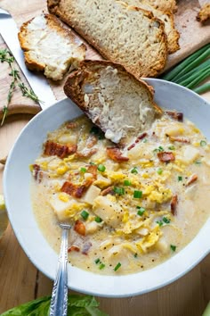 a white bowl filled with soup next to bread