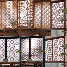 an image of a room divider made out of wood and metal with plants in the corner