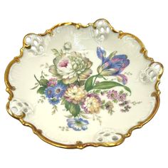 a white and gold plate with flowers on it