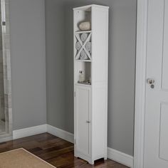 a tall white cabinet sitting in the corner of a room