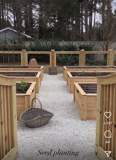 an outdoor garden area with several wooden raised planters and a basket on the ground