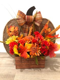 an arrangement of fall flowers in a basket