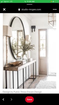 a console table with a mirror, lamp and vase on it in front of a door