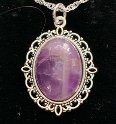 Very nice looking,.  Amethyst is one of the most famous and prominent crystals because of its beautiful coloration as well as its spiritual and literal meaning.  The spiritual meaning of Amethyst is groundedness, tranquility, and calm. The literal meaning of Amethyst is "not intoxicated".  To this ancient, wise culture, the Amethyst crystal was of the utmost importance, and the myth associated with it still lives on inside it to this day.  You can immediately feel peace of mind by simply looking at this brilliant crystal. In fact, its radiant purple and white colors have represented the sobriety of emotions and spirit throughout history.  It is also the traditional gift for a couple's 33rd wedding anniversary because 33 is the number of divine protection. Stone Size: 18x13 mm.   USPS First Mystical Oval Cabochon Jewelry, Purple Necklace With Large Stone For Gift, Spiritual Oval Pendant Crystal Necklace With Gemstone, Vintage Purple Oval Cabochon Jewelry, Silver Necklace With Large Oval Cabochon Stone, Crystal Necklace With Oval Gemstone Pendant For Gifts, Oval Pendant Crystal Necklace With Gemstone For Gift, Gift Crystal Necklace With Oval Gemstone Pendant, Gift Oval Pendant Crystal Necklace With Gemstone