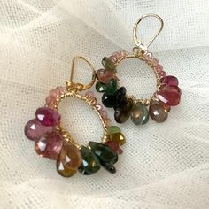 A pair of watermelon tourmaline earrings dangle hoop earrings in 14K gold-filled.  The look is glamorous and elegant.  Nicest quality natural gemstones wire wrapped on 20 gauge hoops, hang from gold filled lever backs. Large (10mm) faceted tourmaline beads and briolette are attached by wire one at a time, covering the full-colour range of the gemstone.   The earrings are approx. 2 inches in length. These earrings are handmade by me in Toronto. Each one is unique.  All metal components used are 1 Handmade Tourmaline Dangle Earrings, Round Tourmaline Gemstone Earrings, Tourmaline Teardrop Gemstone Earrings, Teardrop Tourmaline Gemstone Earrings, Tourmaline Gemstone Drop Earrings, Handmade Tourmaline Dangle Jewelry, Tourmaline Drop Earrings, Connector Earrings, Statement Earrings Gold