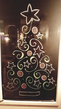 a christmas tree drawn on a glass door with stars and swirls in the shape of a star