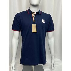 Burberry Icon Stripe Placket Cotton Piqu Polo Shirt A Classic Polo Shirt Style, Burberry Elevates This Short-Sleeved Piece With Signature Details. In A Navy Blue Colourway, It Is Embroidered With A Tb Monogram Motif, While The Icon Stripe Is Seen At The Placket. Highlights A Classic Polo Shirt In Airy Cotton Piqu, Updated With An Embroidered Monogram Motif, Tipped Collar And Our Icon Stripe At The Placket. Cotton 100% Blue Collared Polo Shirt Preppy Style, Preppy Blue Collared Polo Shirt, Luxury Navy Top For Workwear, Luxury Navy Tops For Work, Luxury Navy Top For Work, Luxury Blue Cotton Shirt, Designer Short Sleeve Tops With Placket, Designer Cotton Tops With Striped Collar, Designer Cotton Tops With Collared Neckline