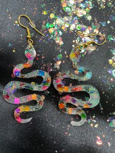 "Don't Be a Snake, Check These OUT! Party Snake Earrings! Made from resin, rainbow confetti mylar square glitter and fine white glitter with gold split rings and gold fish hook findings. All connections are soldered for durability.  Earrings measure 2 3/4\" inch in drop length by about a 1 1/8\" inch in width." Multicolor Glitter Dangle Earrings, Multicolor Glitter Drop Earrings, Multicolor Resin Jewelry For Party, Trendy Multicolor Glitter Jewelry, Fun Resin Jewelry For Parties, Fun Resin Jewelry For Party, Multicolor Resin Jewelry With Glitter, Fun Resin Party Jewelry, Iridescent Glitter Earrings For Party