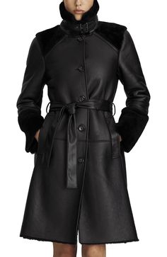 The Astrid is our modernized take on a classic trench coat suited for colder weather. Made from ultra-soft leather, statement cuffs, a distinctive buckled collar, and welt pockets, it brings a new level of sophistication to seasonal warmth, no matter what you're wearing or where you're going. Cinch it closed with the optional tie belt, or leave it open for a more relaxed look. Genuine leather and shearling Wind resistant Logo engraved button front closure Optional tie belt Buckle closure for col Black Leather Outerwear With Belted Cuffs, Leather Outerwear With Belted Cuffs For Business, Business Leather Outerwear With Belted Cuffs, Modern Belted Leather Outerwear, Designer Black Outerwear With Belted Cuffs, Black Designer Outerwear With Belted Cuffs, Formal Leather Outerwear With Belted Cuffs, Designer Winter Outerwear With Belted Cuffs, Modern Black Outerwear With Belted Cuffs