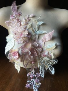 the back of a mannequin with flowers and leaves on it