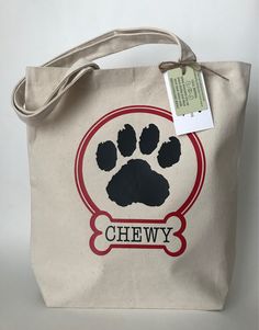 a bag with a paw print on it and a tag hanging from the bottom that says chewy