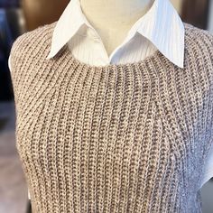 a mannequin with a sweater on it's chest and collar, in front of a white shirt