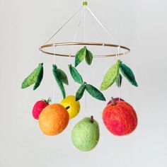 an apple, orange, and pear mobile hanging from a wire