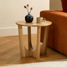 a small table with a vase on it next to a couch