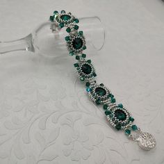 Handmade beaded bracelet featuring a gorgeous combination of sterling silver seed beads, green delica beads, emerald green bicones and Swarovski emerald crystal rivolis with a filigreed box closure. The bracelet is approximately 6.75 beaded inches long.  You'll love wearing this elegant beaded bracelet! Keep it for yourself or give someone a beautiful gift!  I can make almost any color combo  or make it specifically to your wrist size upon request.  Please contact me with desired colors and  wrist size and I will do the rest.  Ready to ship.  Design by Deb Roberti. Attention! Colors may look different depending on your monitor settings. Jewelry Care:  To keep the materials in your jewelry in good condition, do not wear while swimming, bathing, or heavily exercising. Avoid contact with abra Green Sterling Silver Beaded Bracelet, Green Beaded Sterling Silver Bracelet, Green Sterling Silver Bracelets With Silver Beads, Green Sterling Silver Bracelet With Silver Beads, Beaded Emerald Jewelry Gift, Elegant May Birthstone Beaded Bracelets With Faceted Beads, Elegant May Birthstone Faceted Beaded Bracelets, Elegant Crystal Bracelets With Spacer Beads, Elegant Green Crystal Bracelets