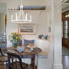 a dinning room table and chairs in front of an entry way with white walls