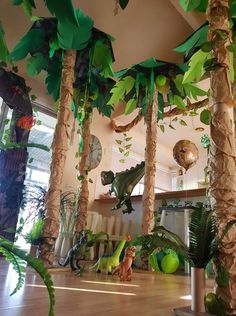 a room filled with lots of palm trees and fake animals hanging from the ceiling next to each other