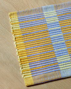 a yellow and blue rug sitting on top of a wooden floor