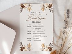 the wedding program is displayed on a white tablecloth with dried flowers and greenery