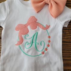 Shirt features a large Bow wreath surrounding your choice of single letter monogram. Available in a range of sizes from infant to youth. Listing is for shirt only. Colors in photos may appear differently on different devices. Single Letter Monogram, Monogram Shirt, Bow Wreath, Monogram Shirts, Letter Monogram, Monogram Wreath, Single Letter, Shirt Embroidery, Large Bow