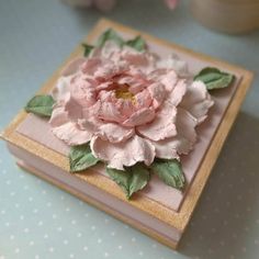 a pink flower sitting on top of a book