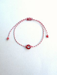 Martis bracelet, Waxed cord bracelet, March bracelets, Red and White, Twisted string, Enamel charm, Evil eye charm, Greek custom, Tradition The March bracelet is an ancient Greek custom. From the beginning of March, people wear a bracelet made of white and red twisted thread. According to the tradition, the March bracelet protects those from burning of the first sun of spring. The last day of March,the bracelet is left on trees so that swallows can use it for building their nests. The price is f Hand Wrapped Beaded Bracelets With Waxed Cord As Gift, Resizable Beaded Bracelets As Gift, Red Waxed Cord Friendship Bracelets, Gift Braided Bracelets With Adjustable Cord And Round Beads, White Nylon Cord Friendship Bracelets As Gift, Red Waxed Cord Bracelet With Sliding Knot, Handmade Red Braided Bracelets With Nylon Cord, Handmade Red Jewelry With Waxed Cord, Handmade Red Braided Nylon Cord Bracelets