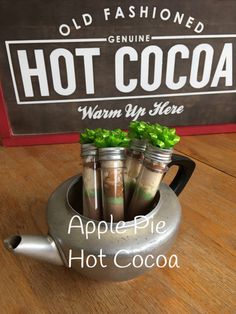 an old fashioned hot cocoa machine with four cups filled with coffee and lettuce in it