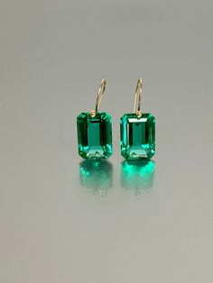 Beautiful  Colombian emerald earrings showcasing brilliant drop-shaped pendants. The faceted rectangular drops are adorned with a stunning Caribbean ocean green hue, which imbues the stones with exceptional depth and reflects light in a breathtaking manner. These fancy drops are expertly affixed to ear wires crafted from either 24K Gold Vermeil or 14K/ 18K Solid Gold, adding a touch of opulence to their elegant and minimalist design. These earrings epitomize sophistication, and minimalism, and e Emerald Jewellery, Colombian Emeralds, Types Of Gemstones, Emerald Earrings, Jewellery Gift, Emerald Jewelry, October Birth Stone, Wow Products, Gifts For Wife