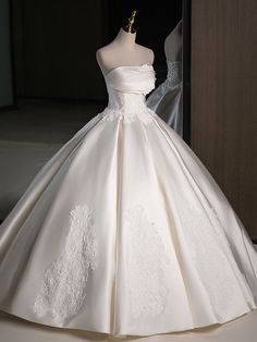 a white wedding dress on display in front of a mannequin