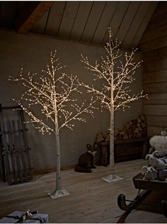 three lighted trees in the corner of a room