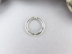 Hand made seamless ring in .999 fine silver hammered for a tapered look. It's hammered for texture on one side and smooth on the other side. The edges have been filed gently by hand to eliminate snagging and improve comfort. You can wear this anywhere! Nostril, septum, tragus, helix, rook, daith, conch, eyebrow, navel, hood, navel, and other piercings. Listing is for 1 piece. How to Choose Seam Location: Generally, you can select the seam on the same side you'll be wearing it. Left seam = left s Silver Hoop Septum Ring For Anniversary, Silver Stackable Small Hoop Cartilage Earrings, Adjustable Internally Threaded Sterling Silver Rings, Adjustable Silver Nose Rings For Everyday, Silver Stackable Septum Ring As Gift, Silver Stackable Small Hoop Rings, Hoop Septum, Tragus Jewelry, Huggie Earrings Gold