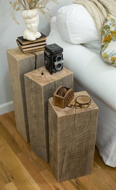 three wooden logs stacked on top of each other in front of a bed