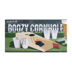 a wooden board game set with cups and drinks on the table in front of a sign that says boozy cornhole