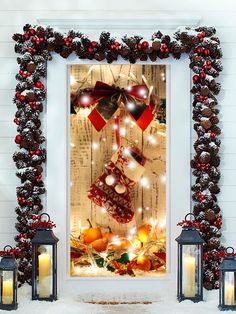 a decorated christmas window with candles and stockings on it in front of a white wall