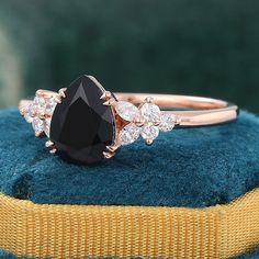 a black diamond ring sitting on top of a blue cushion