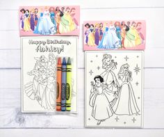 two coloring pages with princesses on them next to markers and crayon pens