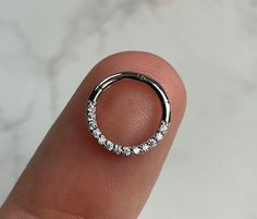 a close up of a person's finger with a ring on top of it