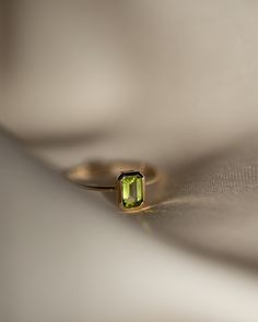 The octagon-shaped peridot on this ring is both eye-catching and elegantly simplistic. It is the perfect way to celebrate a special August birthday or simply adorn oneself with its stunning light green hue. Metrical : 14-karat Yellow Size: Band measures 1mm, Peridot measures 6x4mm Dainty Emerald Cut Solitaire Birthstone Ring, Elegant Green Peridot Stackable Rings, Emerald Cut Peridot Gemstone Jewelry, Elegant Lime Green May Birthstone Ring, Dainty 14k Gold Birthstone Ring With Emerald Cut, Dainty 14k Gold Emerald Cut Birthstone Ring, Lime Green Peridot Ring For May Birthstone, Lime Green Peridot Birthstone Ring For May, Green Octagon Birthstone Jewelry