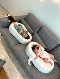 two small children laying on top of a couch