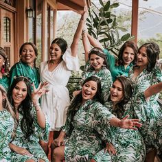 a group of women in matching green and white outfits posing for the camera with their hands up