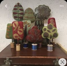 a bunch of different colored thread spools sitting on top of a wooden table