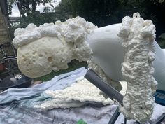 a large piece of white cake sitting on top of a table next to a knife