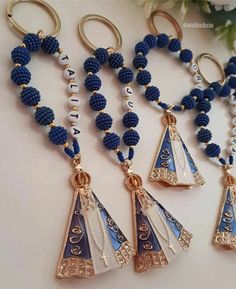 three blue and white beaded necklaces hanging from gold - toned metal hooks