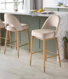 two beige bar stools sitting in front of a counter