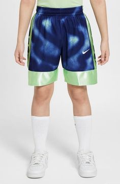 a young boy wearing blue and green shorts with the word nike written on the side