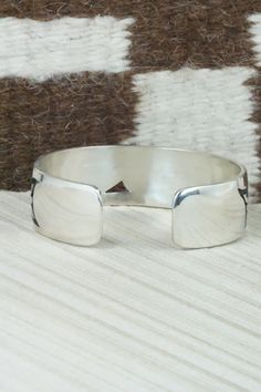 This sterling silver bracelet was made by Hopi silversmith Timothy Mowa. The inside is signed and stamped sterling.Size: 5 3/4" (will fit up to a 6 1/4" wrist)Gap: 3/4"Width: 3/4"Free shipping on all orders! We ship with USPS and always include tracking. All orders ship within a day of payment.Returns are accepted up to 30 days after you receive your order. Just send us a message. Our shop offers cash back or store credit. The item must be returned in new condition. Southwestern Silver Cuff Bracelets, Sterling Silver Jewelry With Thick Band, Unique Jewelry With Polished Finish And Thick Band, Sterling Silver Collectible Bangle, Classic Adjustable Sterling Silver Bracelet Stamped 925, Sterling Silver 925 Stamped Bracelets For Anniversary, Classic Adjustable Sterling Silver Bracelet 925, Adjustable Sterling Silver Bangle, Classic Wide Band Adjustable Bracelets