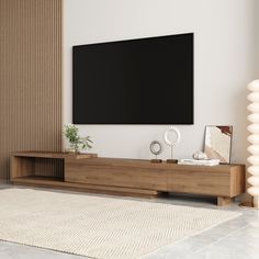 a large flat screen tv mounted to the side of a wooden entertainment center in a living room