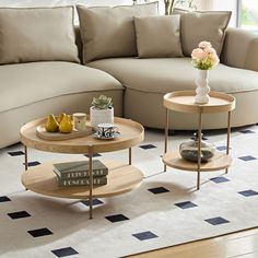 two coffee tables sitting on top of a rug in front of a couch and table