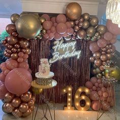 a birthday cake surrounded by balloons and streamers in front of a happy birthday sign