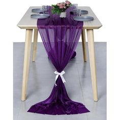 the table is covered with purple sheer curtains